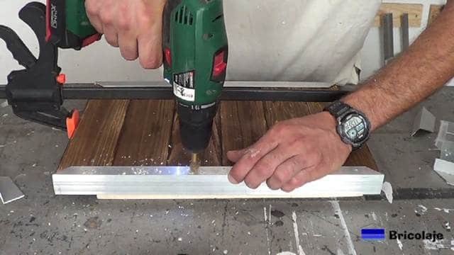 avellanando los agujeros para poder sujetar mediante tornillos la madera de palÃ© a los Ã¡ngulos de aluminio