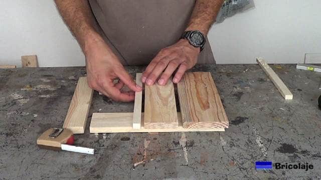 presentando los trozos de madera que formarán la base con ruedas para macetas