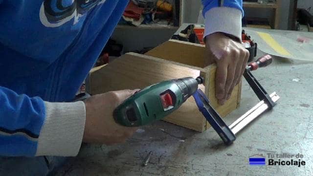 perforando los agujeros para sujetar las piezas de la caja de madera