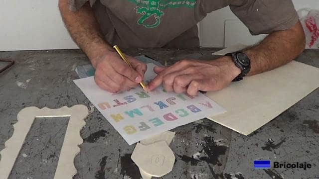copiando las letras en la madera con el papel de carboncillo