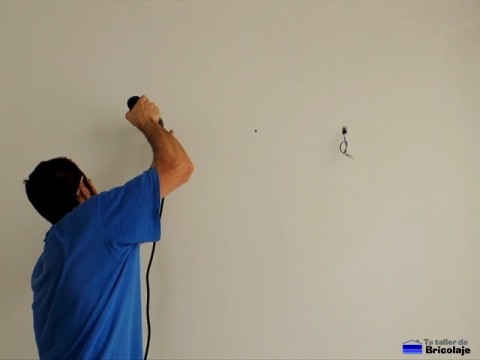 taladrando la pared para colocar el soporte del fluorescente