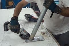 lijando la zonas de soldadura entre el tubo y la pletina para hacer el soporte para la farola solar led