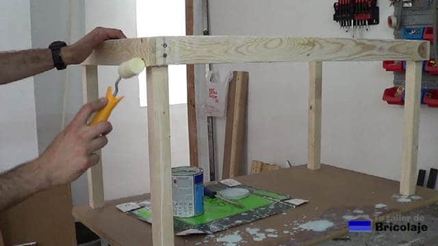 aplicando el tapaporos a la madera de la mesa para niños con tornillos
