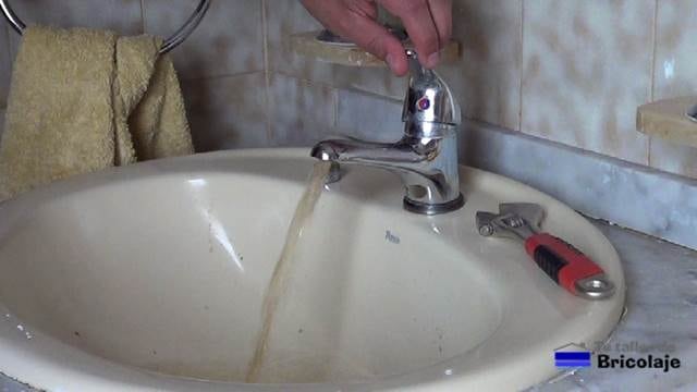 abriendo la llave del grifo del baño sin el aireador para eliminar todas las particulas que se puedan encontrar en el caño del mismo