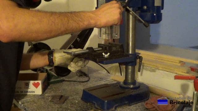 perforando la pletina de hierro con el taladro de columna