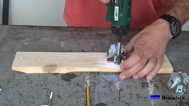 atornillando los soporte a la base de madera del organizador