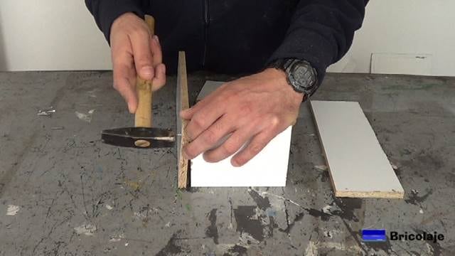 sujetando las piezas de madera con tachas o clavos