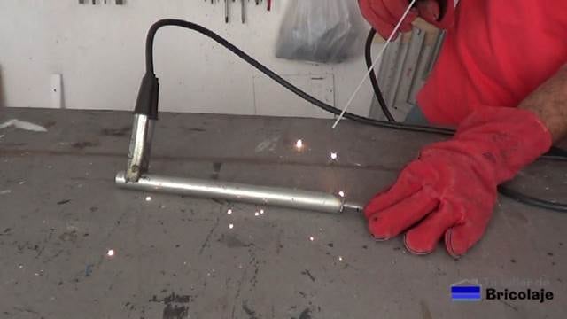 soldando la tuerca en el interior del tubo de hierro