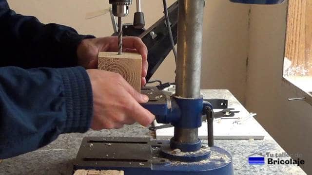 perforando los tacos de madera de palets con el taladro de columna