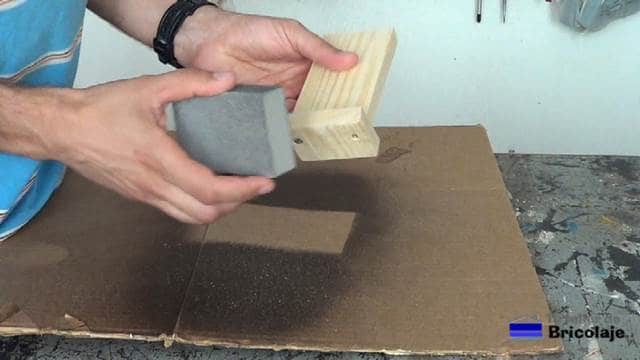 lijando la madera que forma el soporte para el smartphone