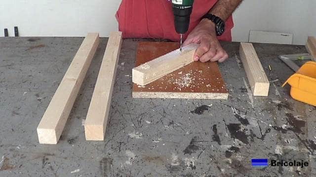 perforando las marcas realizadas para hacer la silla de madera para niños con tornillos