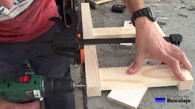 perforando la madera para hacer las patas traseras de la silla de madera para niños con tornillos