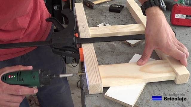 atornillando las patas traseras de la silla