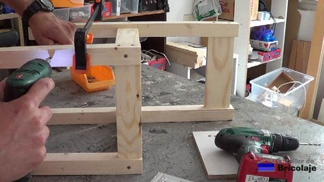 sujetando con tornillos el refuerzo de las patas de la silla