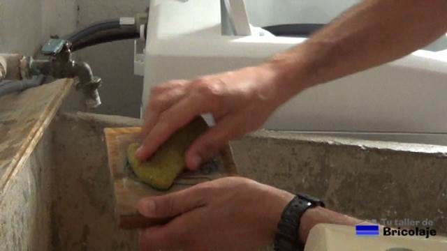 mojando la madera con una esponja